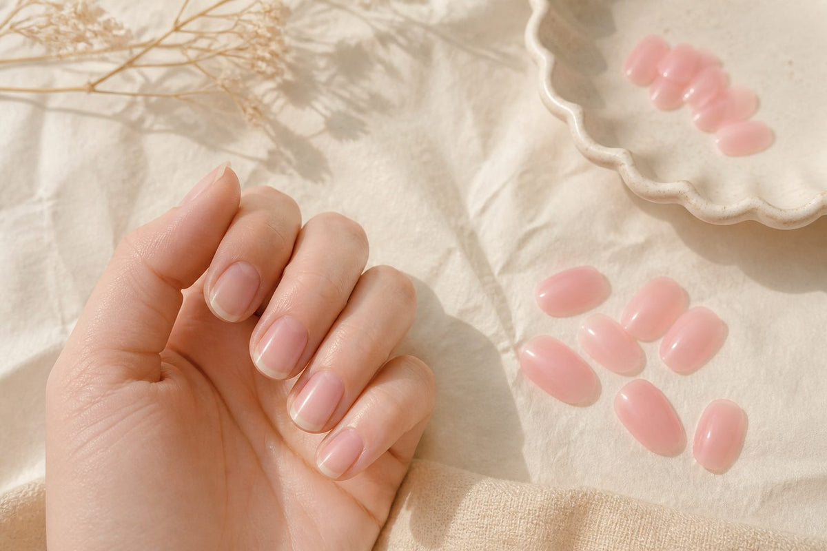 Close-up of healthy-looking natural nails beside a soft almond press-on set