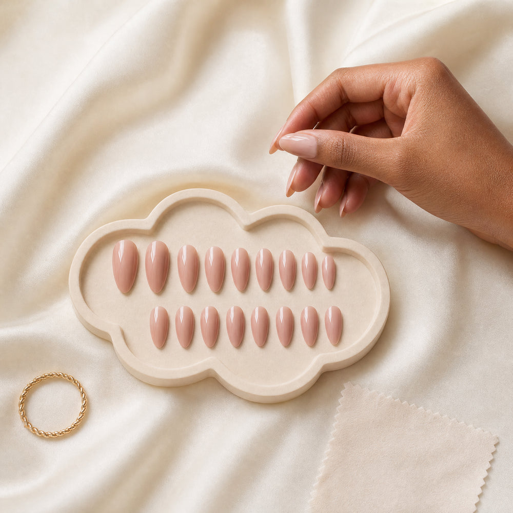 A soft blush press-on nail care scene with a neatly arranged manicure set